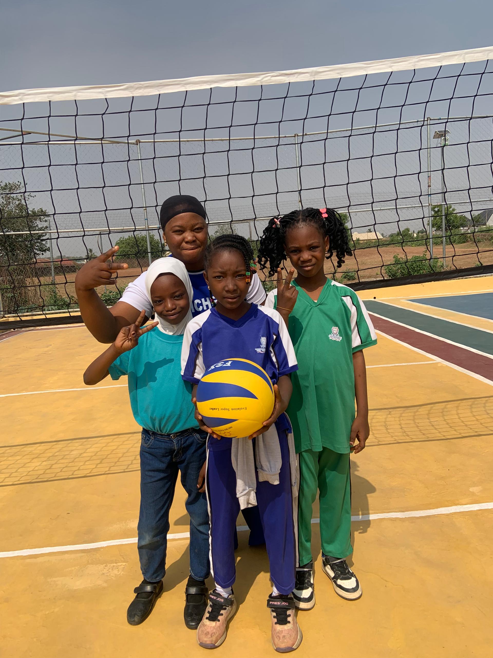 Volleyball squad and coach at net on NBA court